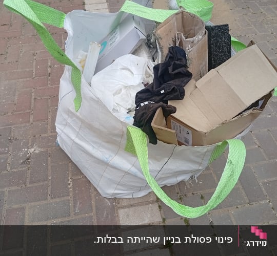 שקית גדולה עם פסולת בנייה על מדרכה